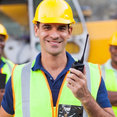 Workers in high visibility clothing hard hats walky talky radio