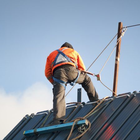 Worker on roof in harness attached